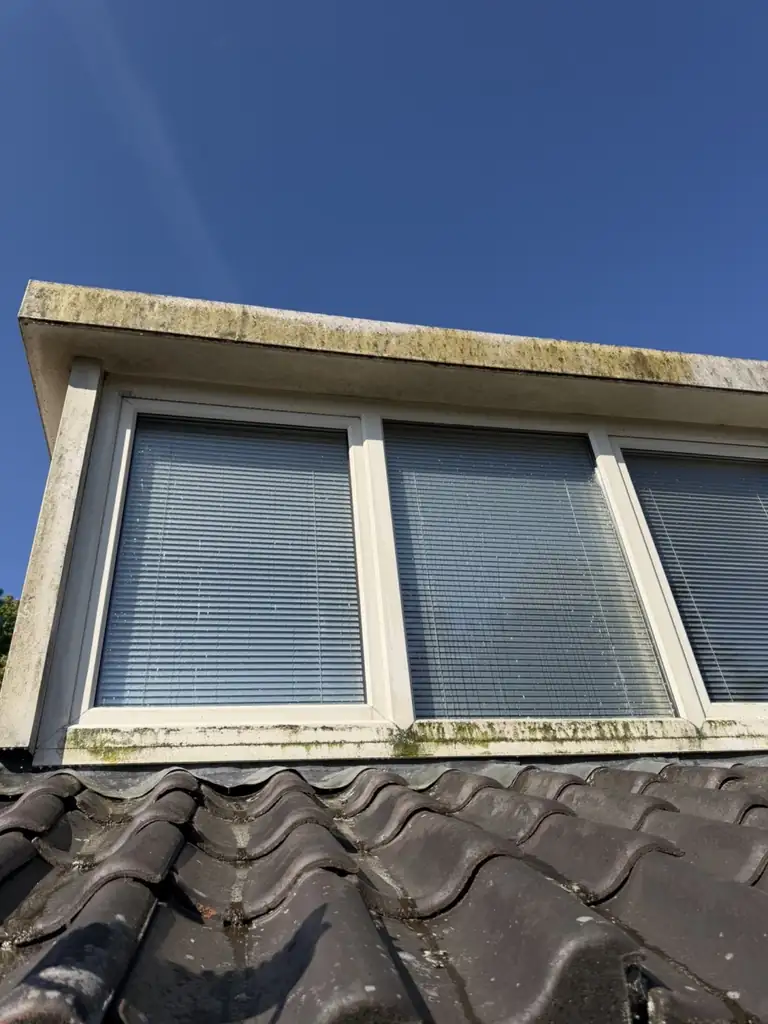 Dakkapel met groene aanslag op kozijn en boeideel in Medemblik — voor de reiniging