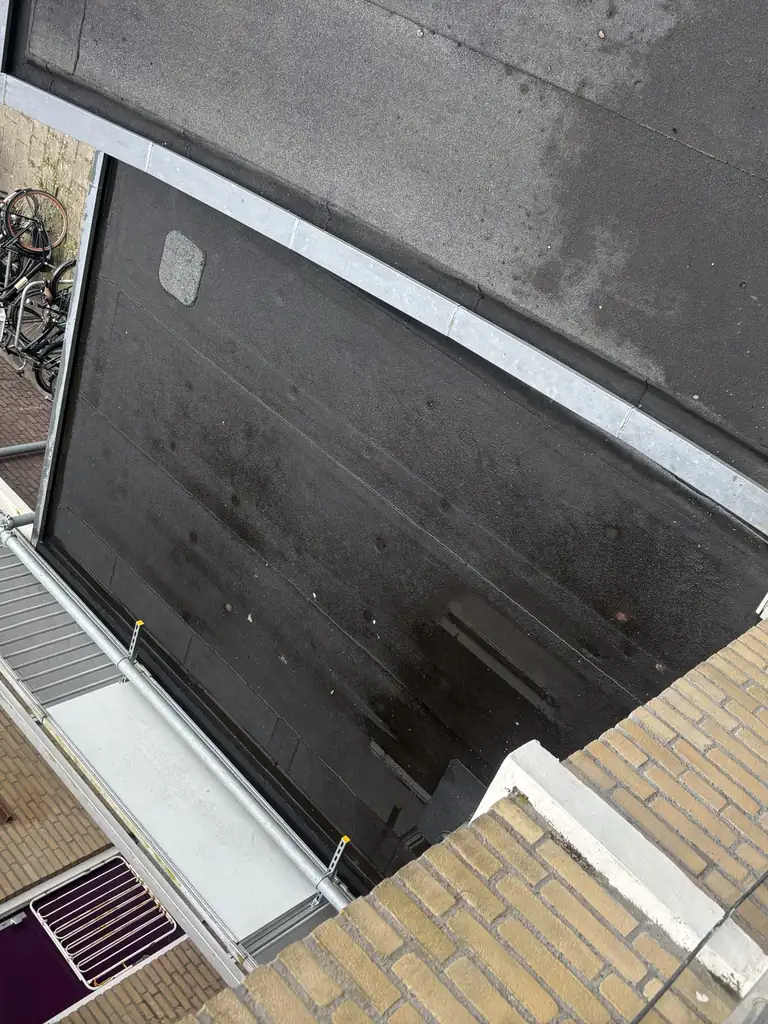 Hetzelfde bitumen dakvlak egaal zwart — na de reiniging